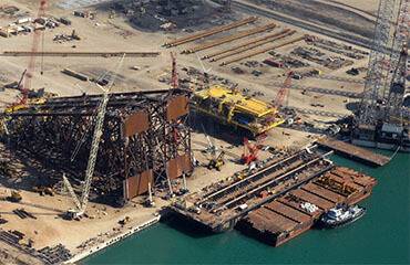 a construction site with cranes and a ship
